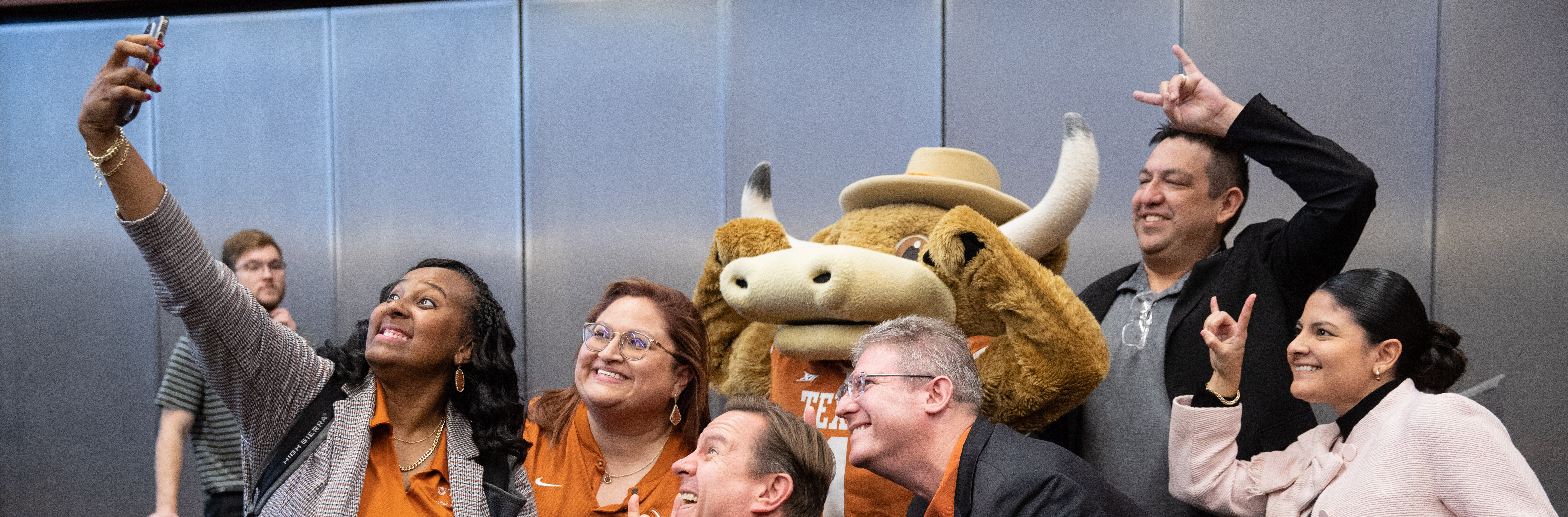Staff members pose for a selfie with Hook Em